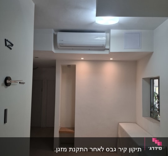 חדר עם מזגן על הקיר ותאורה בתקרה